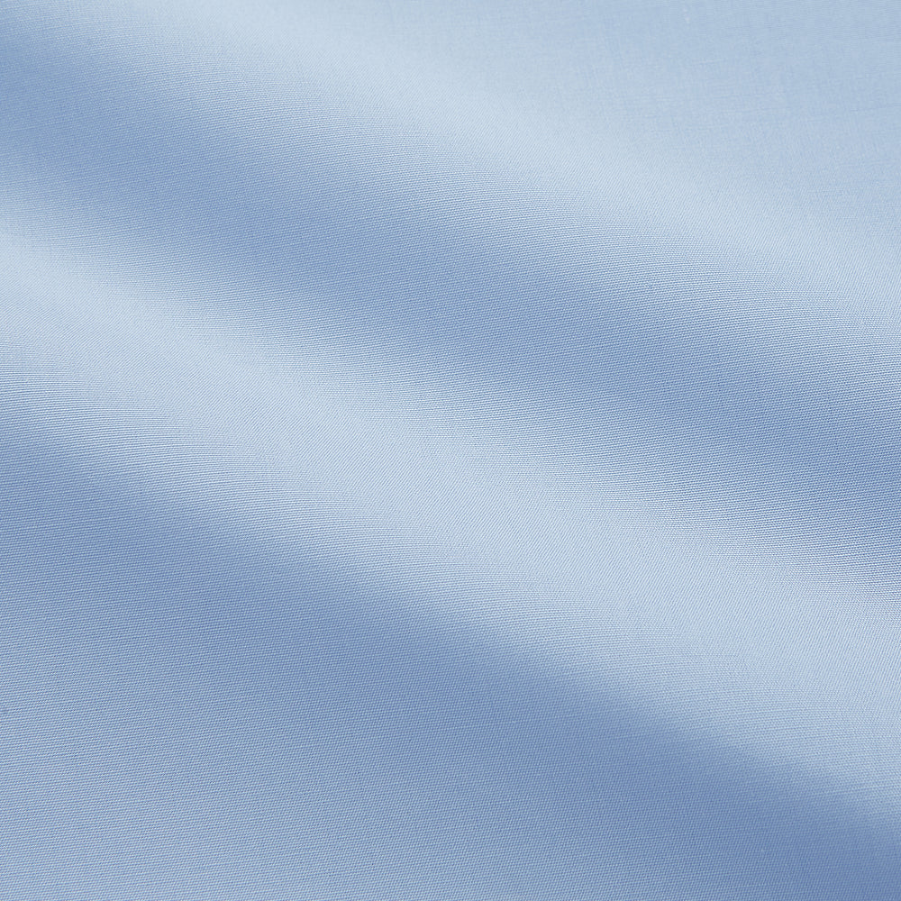 The Turnbull & Asser Light Blue Piped Cotton Nightshirt is a luxurious long-sleeve shirt dress with a pointed collar, black piping on the collar, cuffs, and chest pocket, button front closure, and curved hem.