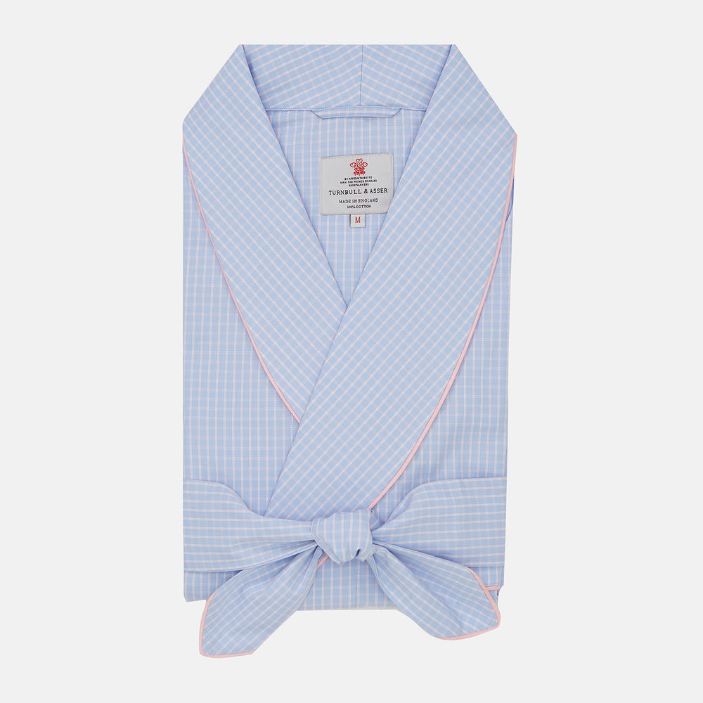 The Turnbull & Asser Blue & Pink Poplin Cotton Check Dressing Gown features a wide collar, pink trim, and a front sash—stylish and compact enough to pack for your next trip.