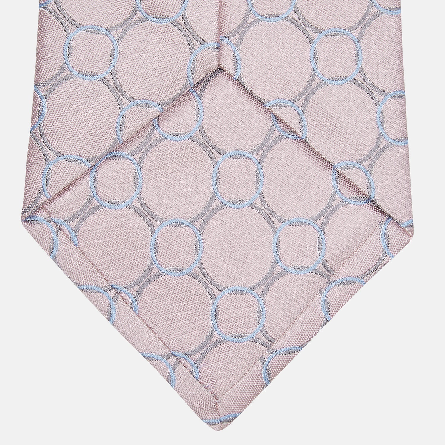 View 3 of product The Turnbull & Asser Baby Pink and Blue Circle Jacquard Silk Tie features a subtle geometric pattern, elegantly rolled against a plain white background.