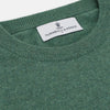View 2 of product The Turnbull & Asser Green Cashmere Crewneck Jumper features long sleeves, ribbed cuffs, and a ribbed hem, shown laid flat on a white background.