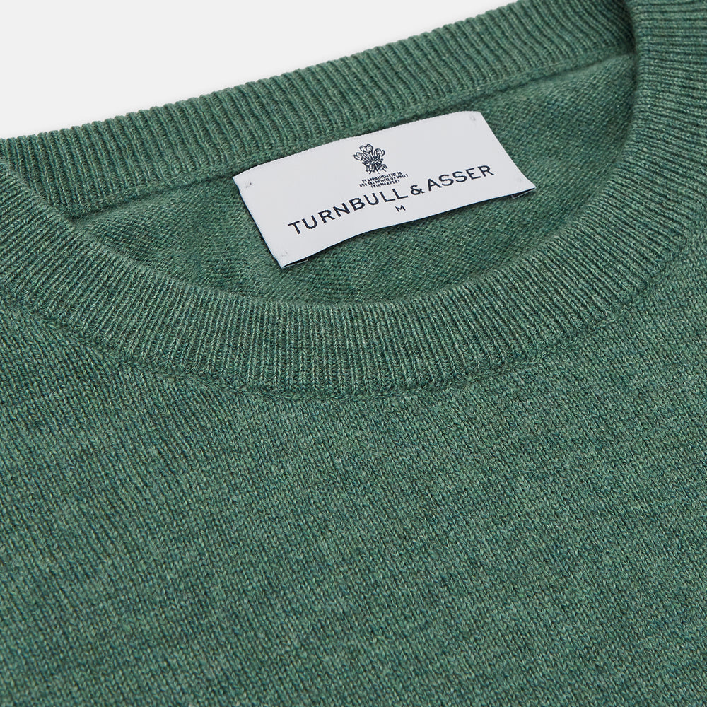 The Turnbull & Asser Green Cashmere Crewneck Jumper features long sleeves, ribbed cuffs, and a ribbed hem, shown laid flat on a white background.