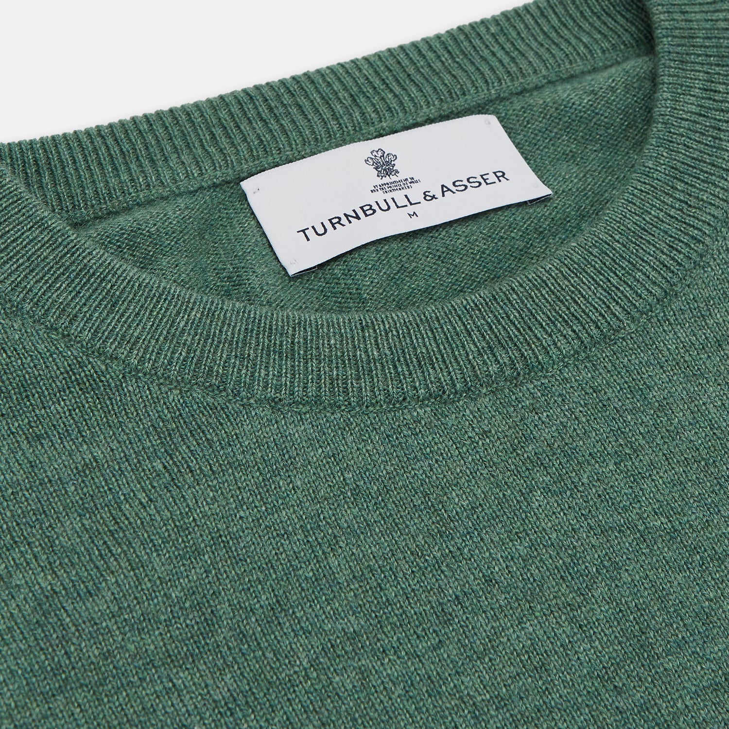 View 2 of product The Turnbull & Asser Green Cashmere Crewneck Jumper features long sleeves, ribbed cuffs, and a ribbed hem, shown laid flat on a white background.