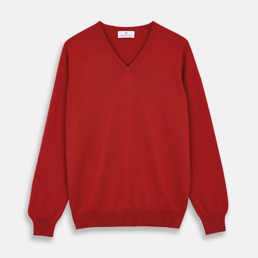 The Turnbull & Asser Red Cashmere V-Neck Jumper features long sleeves and ribbed cuffs and hem, shown laid flat on a white background.