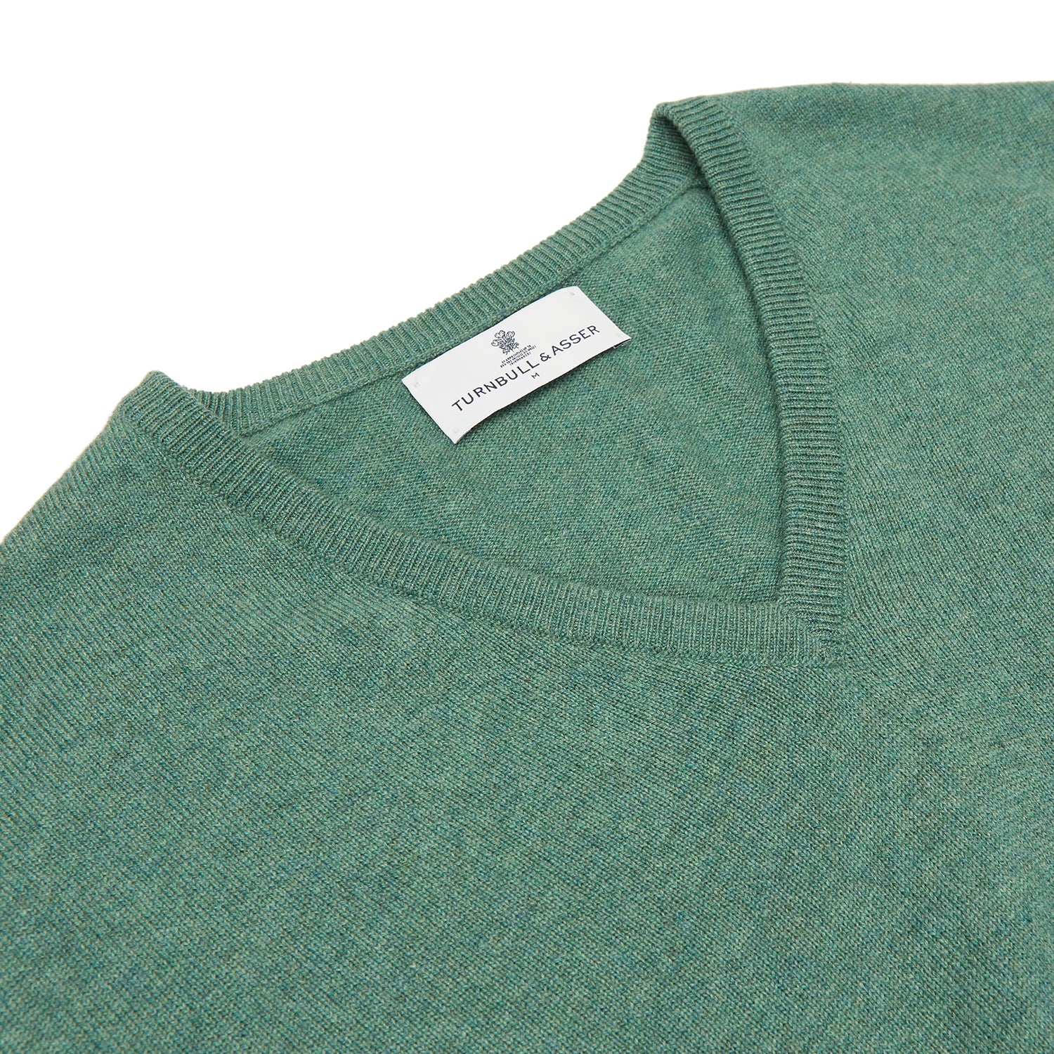 View 2 of product The Turnbull & Asser Green Cashmere V-Neck Jumper features long sleeves, ribbed cuffs and hem, and is styled in classic Scottish knitwear, shown flat against a white background.