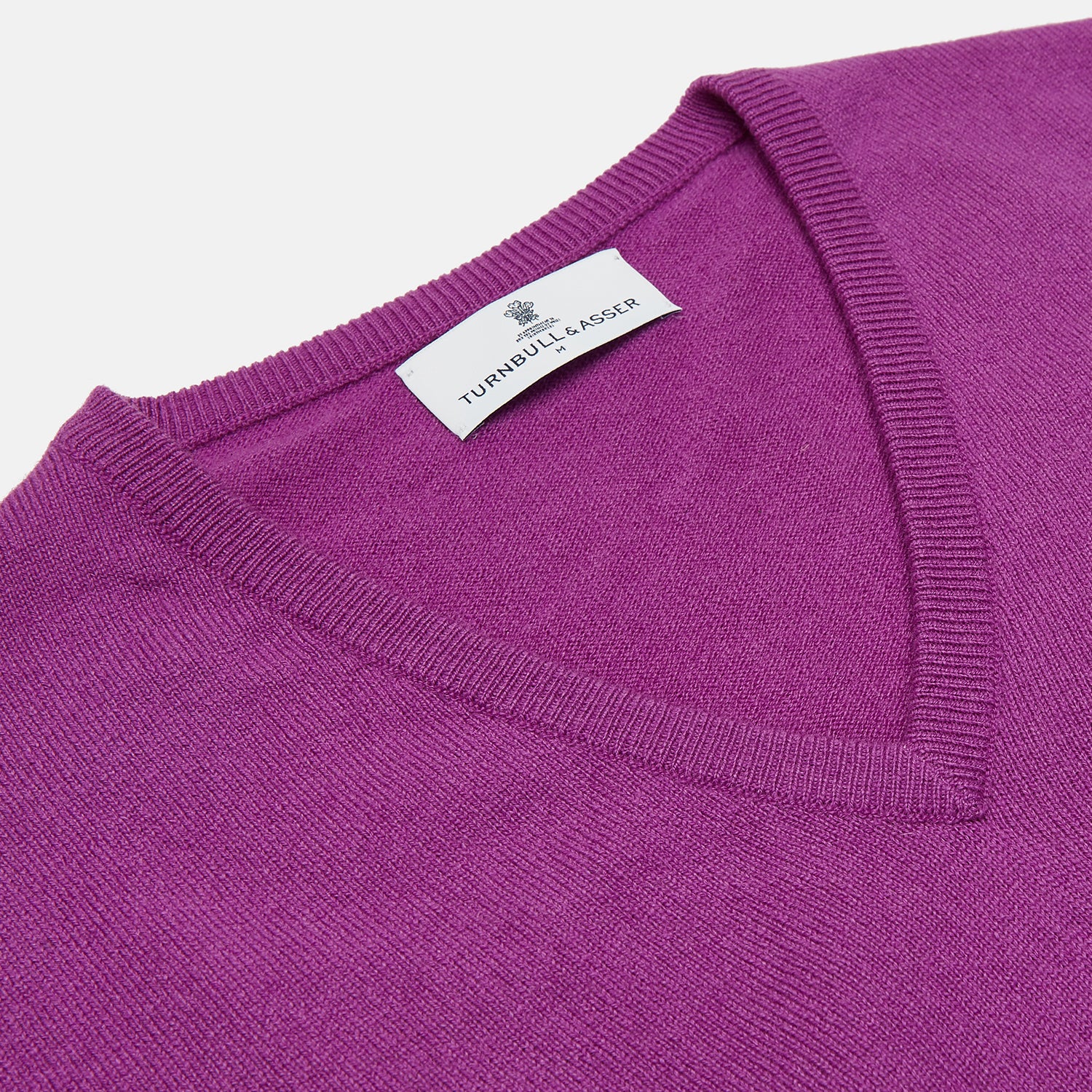 View 2 of product The Turnbull & Asser Magenta Cashmere V-Neck Jumper features long sleeves, ribbed cuffs, and a ribbed hem, shown against a plain white background.