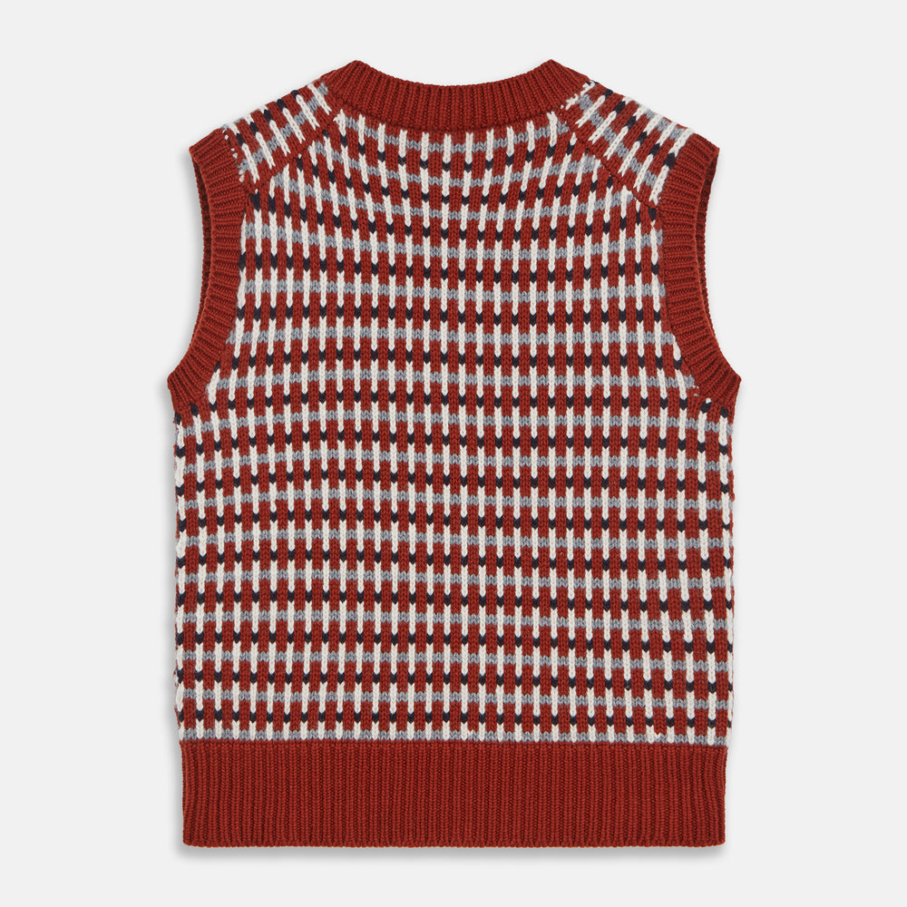 The Rust Knitted Cashmere Slipover by Turnbull & Asser is a sleeveless V-neck vest in red, white, and dark brown houndstooth, inspired by Welsh knitwear with solid red ribbed trim at the collar, armholes, and hem.