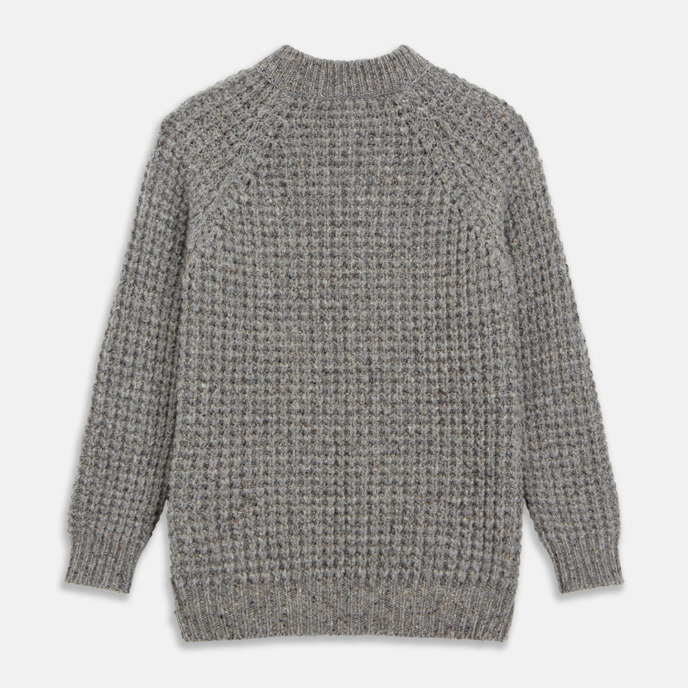 The Turnbull & Asser Merino Knitted Raglan Sleeve Crewneck Jumper in gray features intricate front and sleeve knit patterns, a high neckline, and long sleeves—an essential piece of men’s knitwear. Laid flat on a white background.