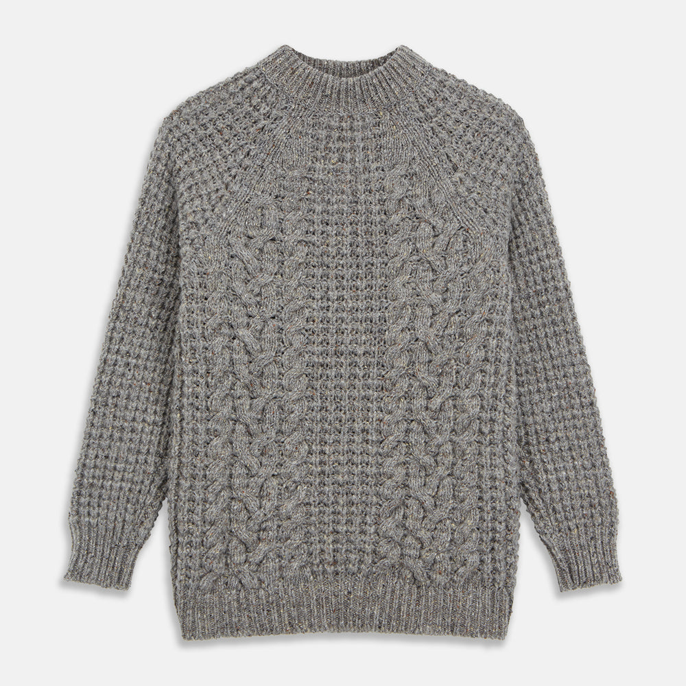 The Turnbull & Asser Merino Knitted Raglan Sleeve Crewneck Jumper in gray features intricate front and sleeve knit patterns, a high neckline, and long sleeves—an essential piece of men’s knitwear. Laid flat on a white background.