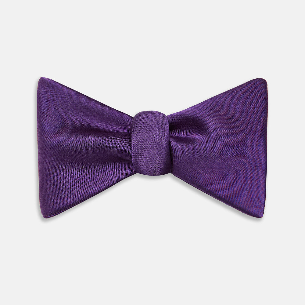 The Turnbull & Asser Plum Plain Satin Silk Bow Tie features a smooth texture and is neatly tied, displayed against a plain white background.