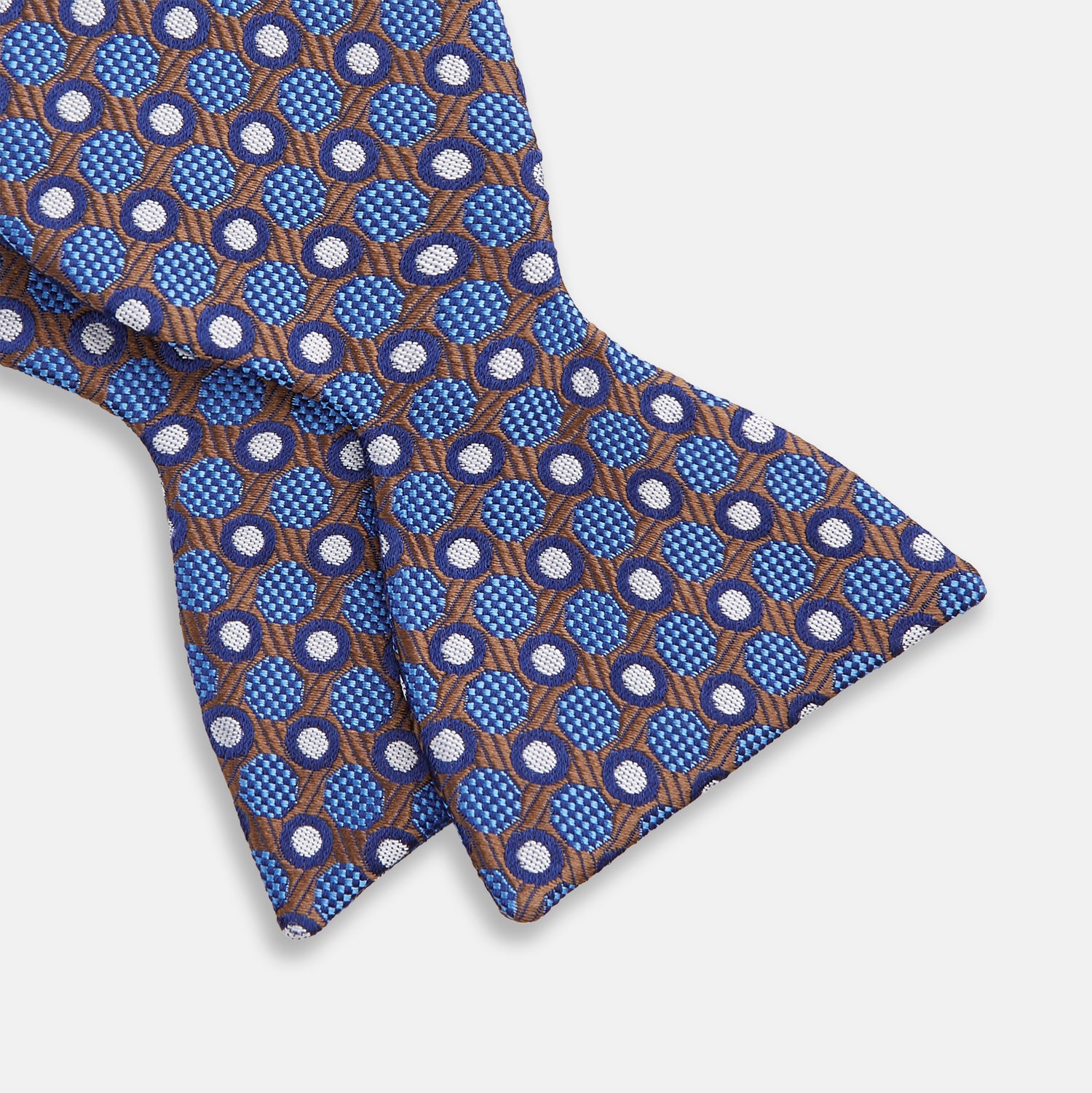 View 3 of product The Turnbull & Asser Brown and Blue Circle and Spot Silk Bow Tie features a blue silk base with light blue and brown circular dots on textured fabric, shown against a white background.