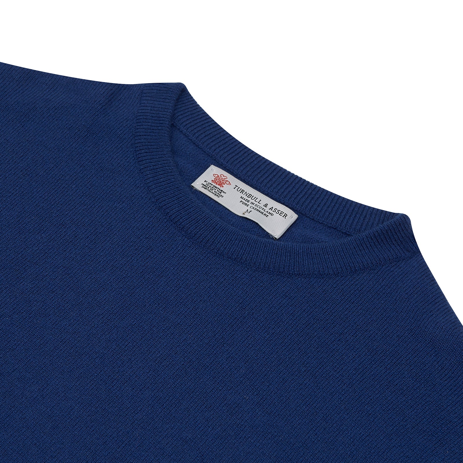 View 2 of product The Turnbull & Asser Blue Crew Neck Cashmere Jumper, neatly folded with ribbed collar and cuffs, is shown on a plain white background. A small label appears inside the collar.