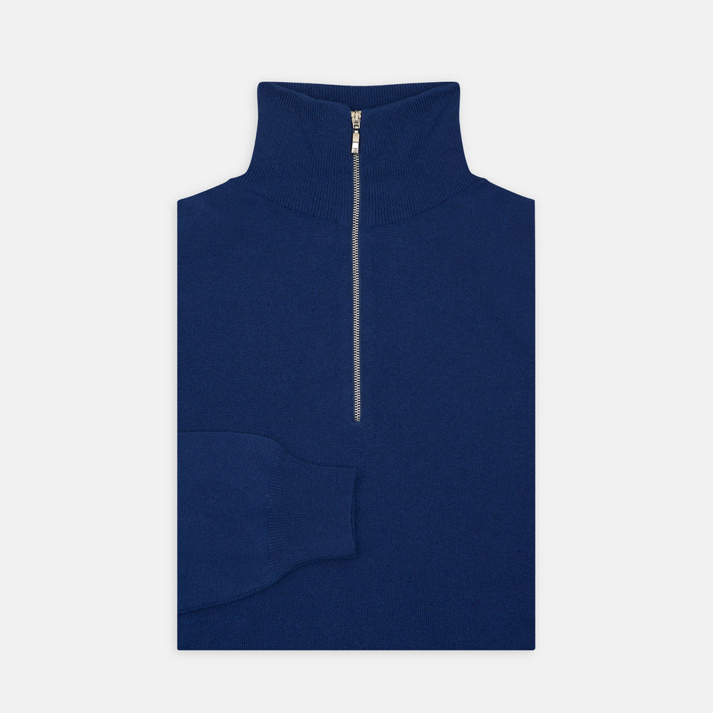 Turnbull & Asser’s Blue Half-Zip Cashmere Jumper with a high collar is neatly folded on a white background, its left sleeve partially tucked under—ideal for winter layering.