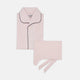 The Pink Sea Island Cotton Pyjama Set by Turnbull & Asser features a folded light pink top with black piping and white buttons, shown beside a matching headscarf with two ties, highlighting luxury men’s sleepwear on a white background.