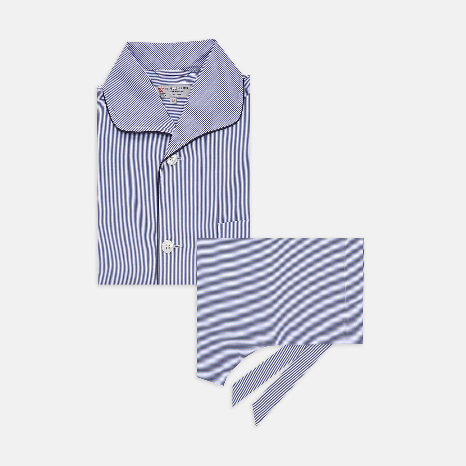 View 1 of product The Blue Fine Bengal Stripe Cotton Pyjama Set by Turnbull & Asser features a blue-and-white striped top with black piping, white buttons, and front pocket, displayed with a matching sleep mask—luxury sleepwear against a crisp white background.