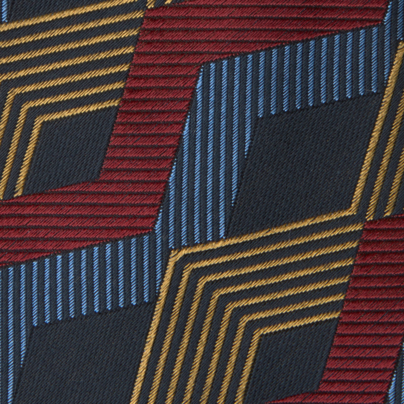 View 2 of product The Navy, Red and Gold Zig Zag Silk Tie by Turnbull & Asser features a geometric pattern of zigzag stripes on a dark background and is part of our limited-run collection.