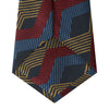 View 3 of product The Navy, Red and Gold Zig Zag Silk Tie by Turnbull & Asser features a geometric pattern of zigzag stripes on a dark background and is part of our limited-run collection.
