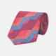 The Turnbull & Asser Red and Blue Zig Zag Silk Tie is a limited-run silk tie featuring interlocking geometric zigzag shapes and diagonal stripes in red, blue, gold, and navy.