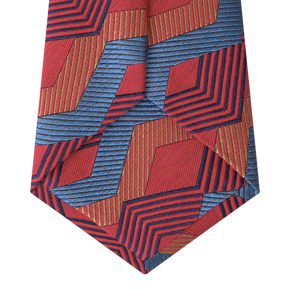 The Turnbull & Asser Red and Blue Zig Zag Silk Tie is a limited-run silk tie featuring interlocking geometric zigzag shapes and diagonal stripes in red, blue, gold, and navy.