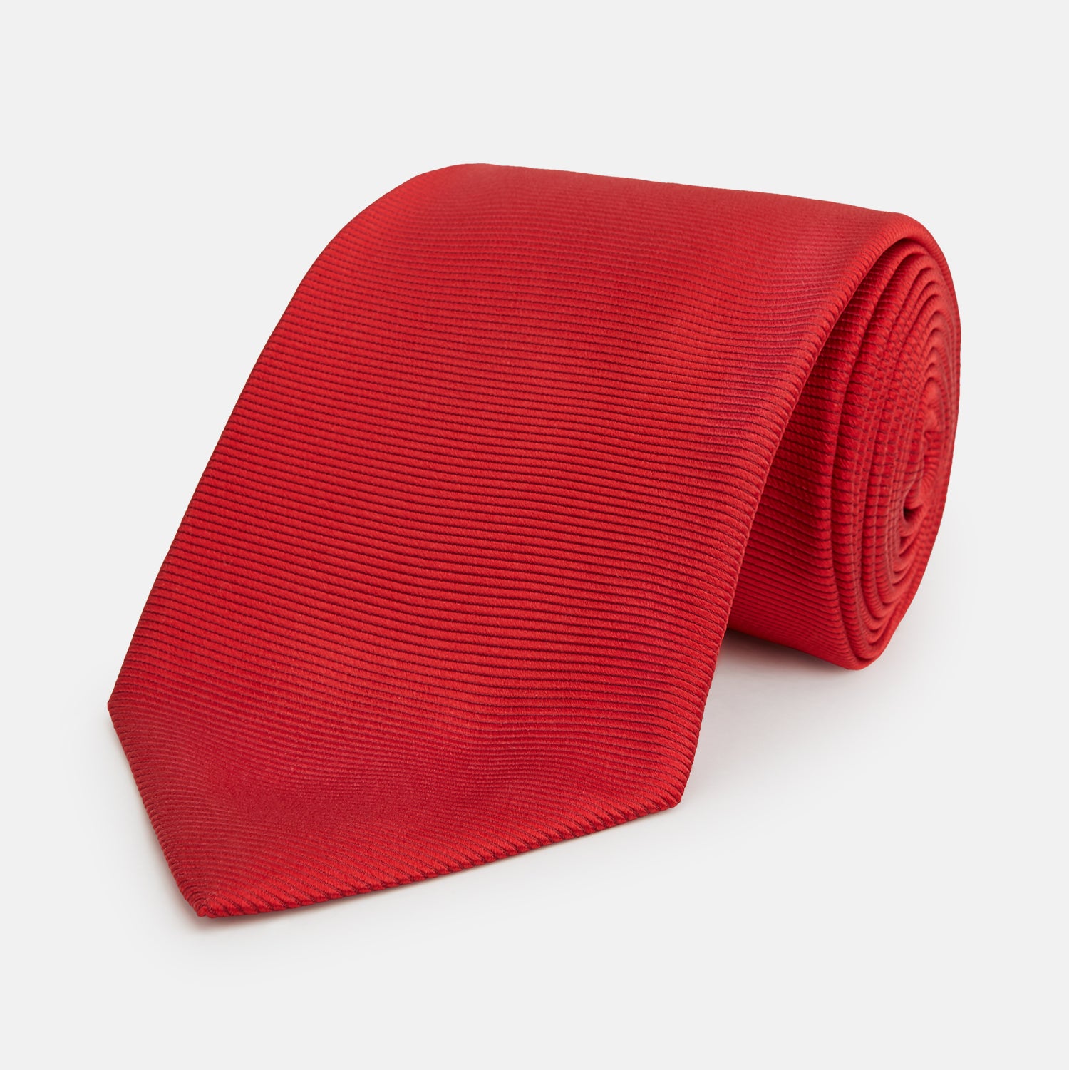 View 1 of product The Turnbull & Asser Red Horizontal Twill Silk Tie, rolled up, is ideal for adding a smart touch to cotton shirts.