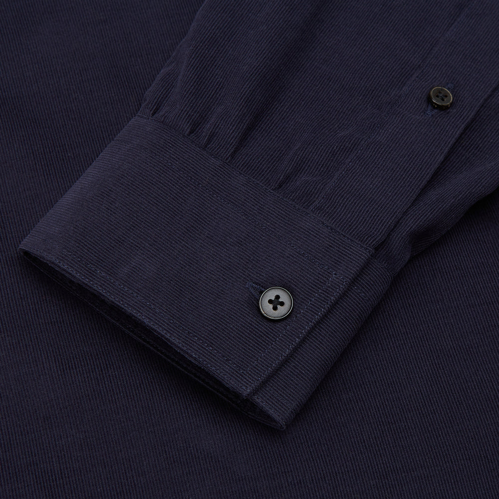 The Turnbull & Asser Midnight Blue Corduroy Officer Weekend Fit Shirt features a soft Dorset collar, relaxed fit, 1-button cuffs, and two button-flap chest pockets, shown on a white background.