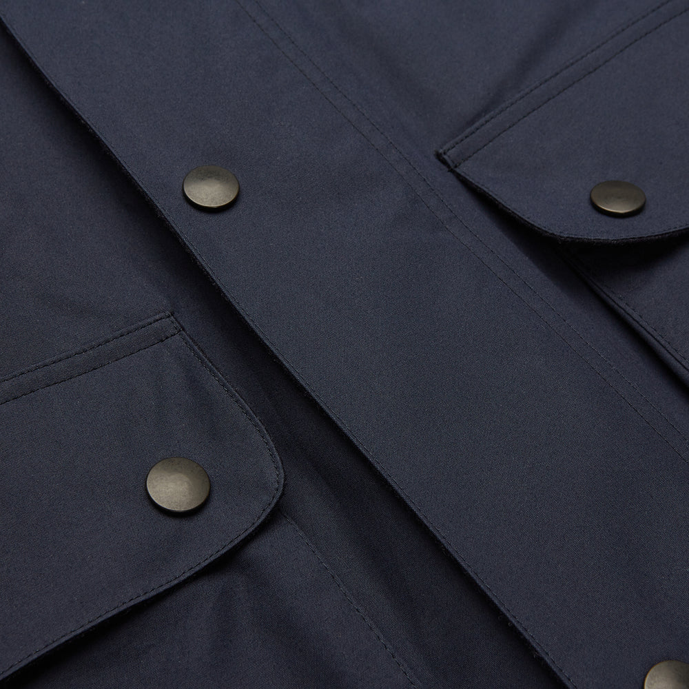 The Turnbull & Asser Navy Dry-Waxed Cotton Field Jacket features a collar, front zipper with snap buttons, two chest pockets, and large hip flap pockets, shown laid flat on a plain white background.