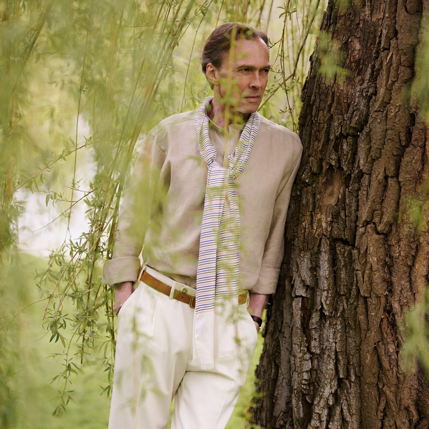View 2 of product A man with a bald head and trimmed beard wears the Turnbull & Asser Beige Weekend Fit Linen Blake Shirt with stand collar and 1-button cuffs, standing calmly against a matching beige background.
