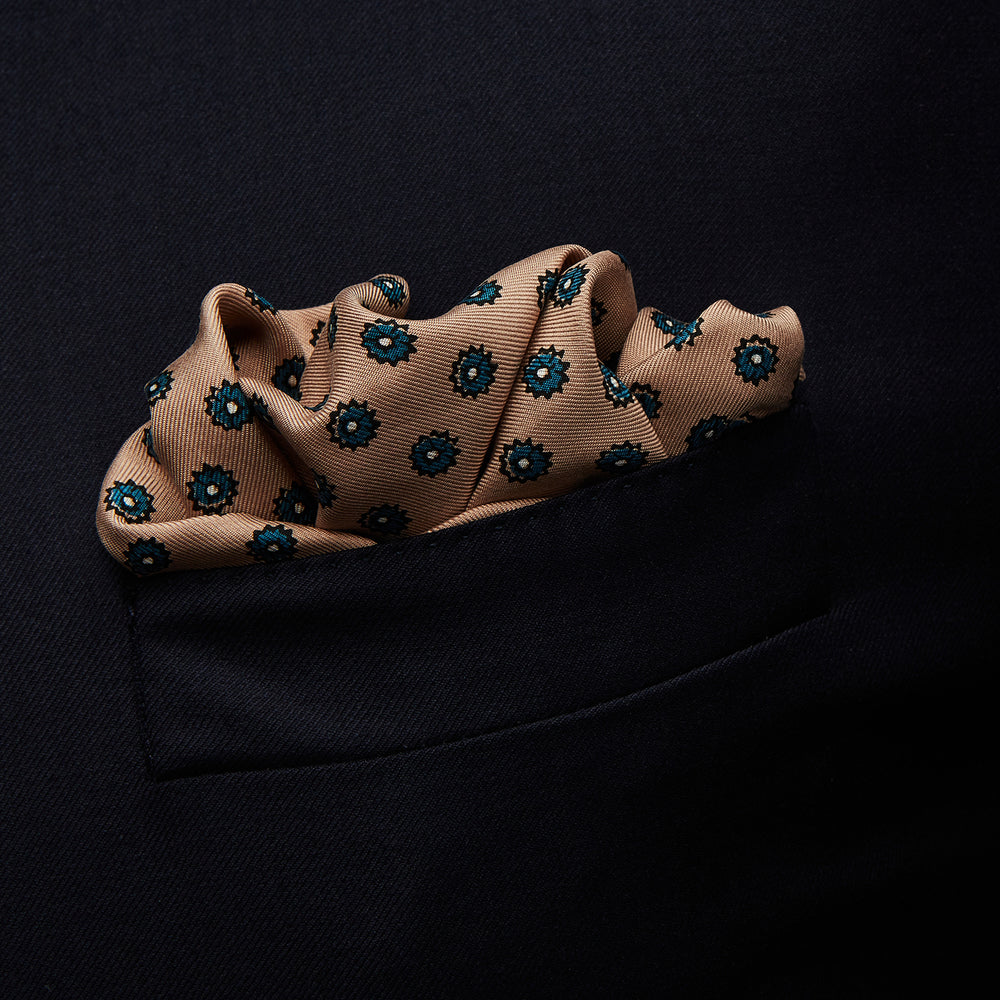 The Copper Fine Floral Print Silk Pocket Square by Turnbull & Asser features a refined floral pattern in silk, with the brand’s name discreetly displayed in one corner—a perfect choice for those who appreciate elegant pocket squares.