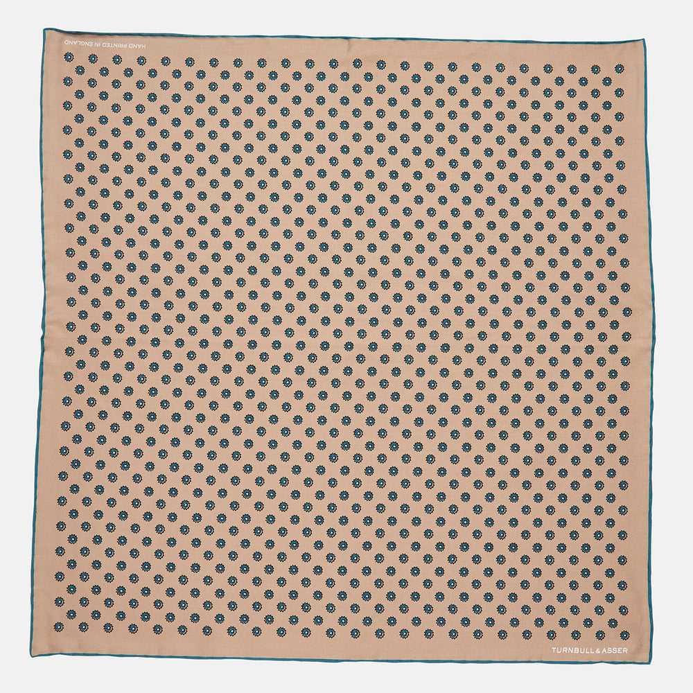 The Copper Fine Floral Print Silk Pocket Square by Turnbull & Asser features a refined floral pattern in silk, with the brand’s name discreetly displayed in one corner—a perfect choice for those who appreciate elegant pocket squares.
