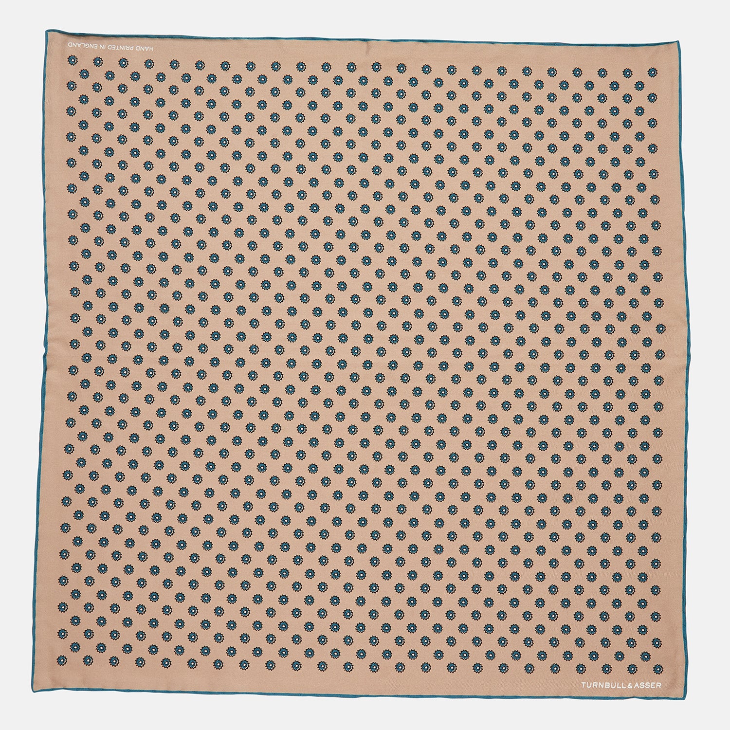 View 1 of product The Copper Fine Floral Print Silk Pocket Square by Turnbull & Asser features a refined floral pattern in silk, with the brand’s name discreetly displayed in one corner—a perfect choice for those who appreciate elegant pocket squares.