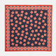 The Navy and Cherry Red Tiled Floral Silk Pocket Square by Turnbull & Asser features a blue background with red and white geometric floral patterns, a decorative border, and the brand's name in one corner.