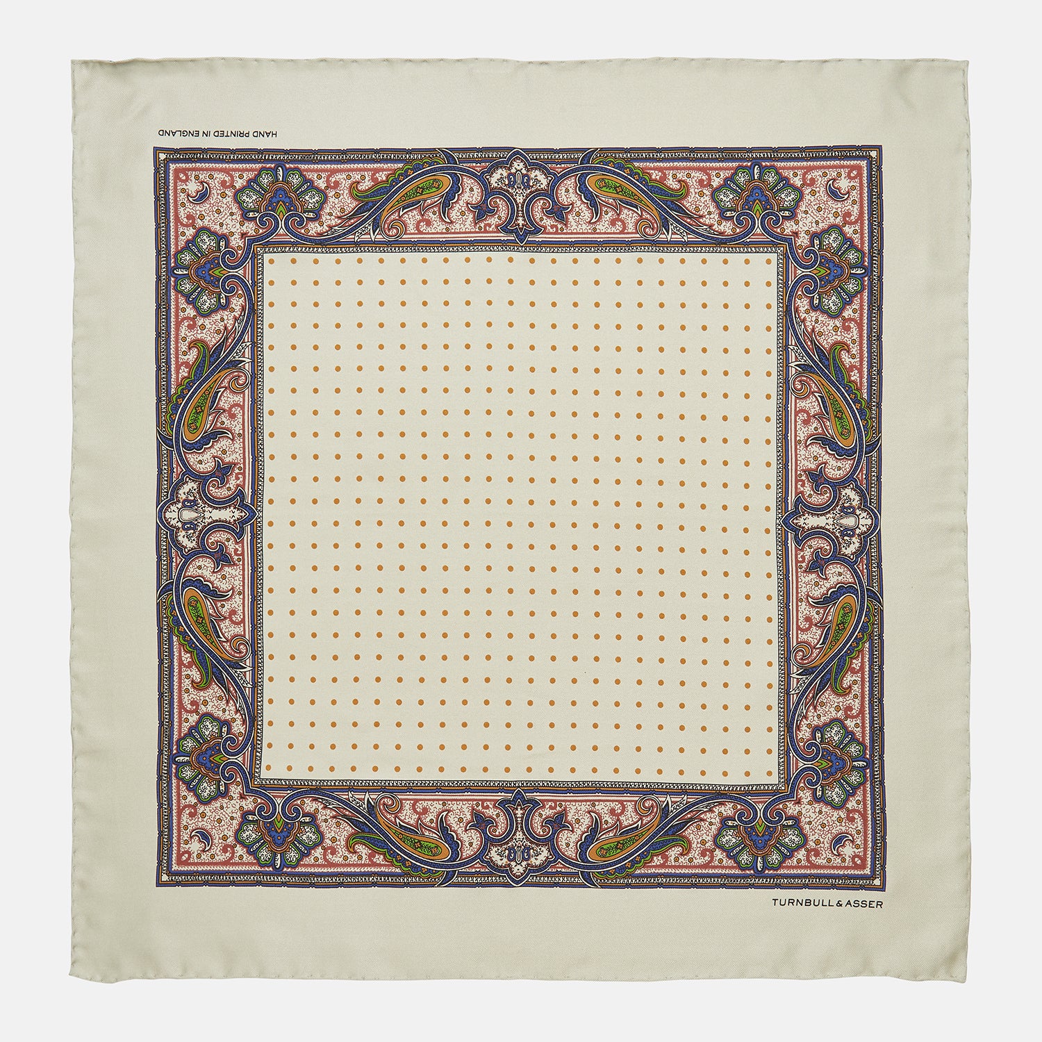 View 1 of product The Cream Paisley Polka Dot Silk Pocket Square by Turnbull & Asser features hand-rolled edges, a detailed blue, red, and yellow paisley design with central orange dots, and the brand's name printed in one corner.