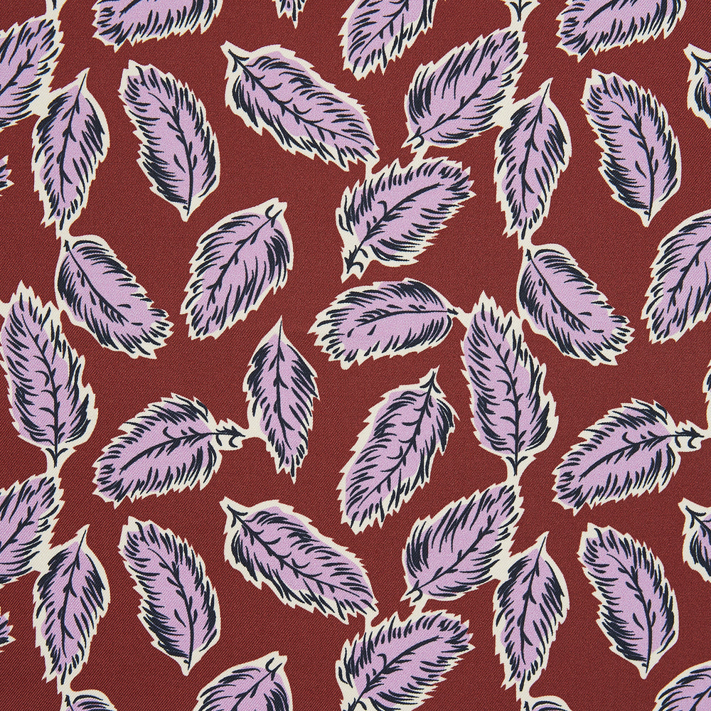 The Red Abstract Feather Print Silk Pocket Square by Turnbull & Asser features a dense purple and black feather pattern on red silk, accented with a discreet brand label—an elegant formal accessory.