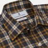 View 2 of product The Turnbull & Asser Yellow Check Weekend Fit Flannel Shirt features a Derby collar, 1-button cuffs, and a yellow, black, and white plaid pattern. It is shown laid flat on a white background.