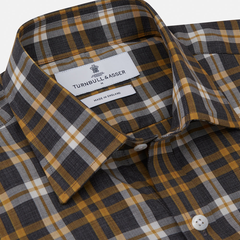 The Turnbull & Asser Yellow Check Weekend Fit Flannel Shirt features a Derby collar, 1-button cuffs, and a yellow, black, and white plaid pattern. It is shown laid flat on a white background.
