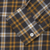 View 3 of product The Turnbull & Asser Yellow Check Weekend Fit Flannel Shirt features a Derby collar, 1-button cuffs, and a yellow, black, and white plaid pattern. It is shown laid flat on a white background.