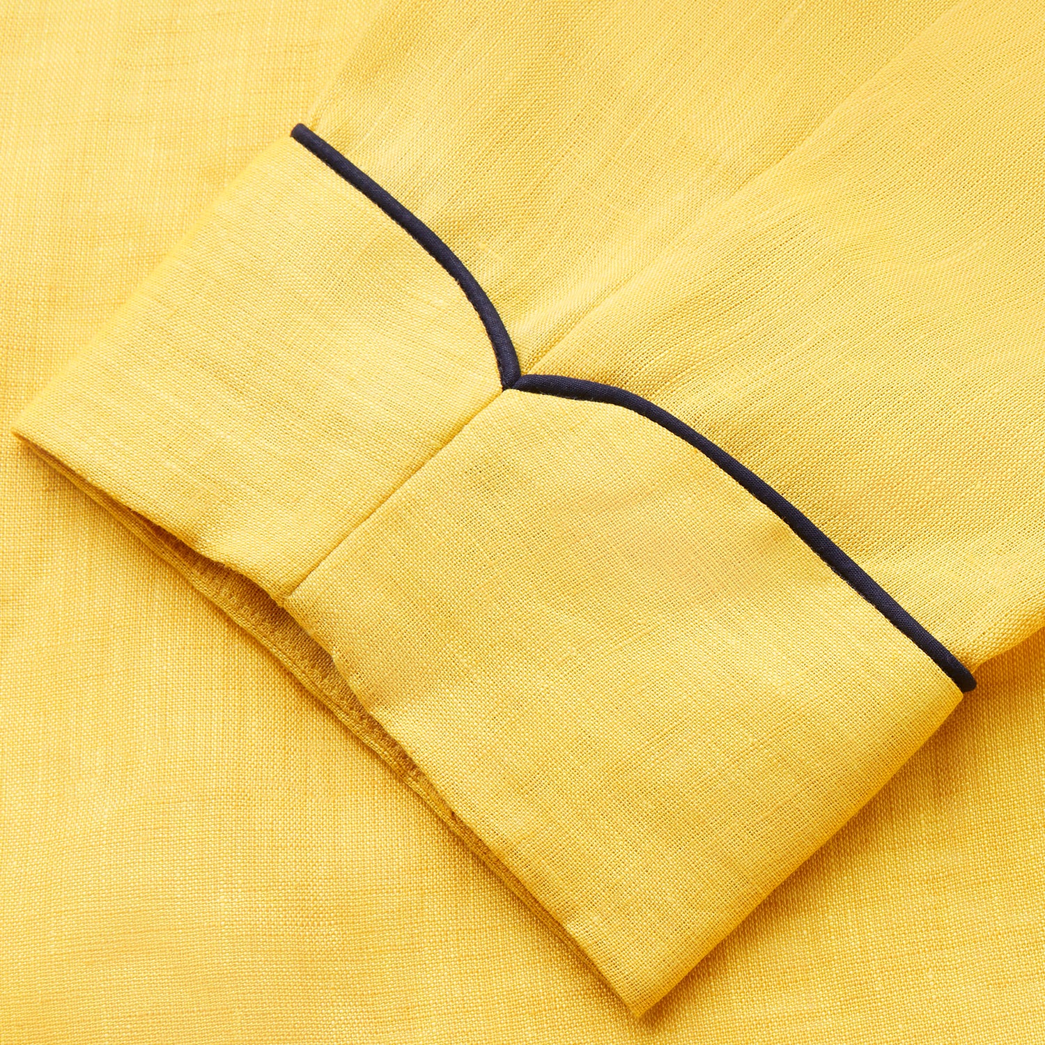 View 6 of product The Turnbull & Asser Ochre Linen Piped Gown features black piping on the collar, cuffs, and edges, a chest pocket, two front pockets, and a matching waist belt. Made with breathable linen for comfort, shown against a plain white background.