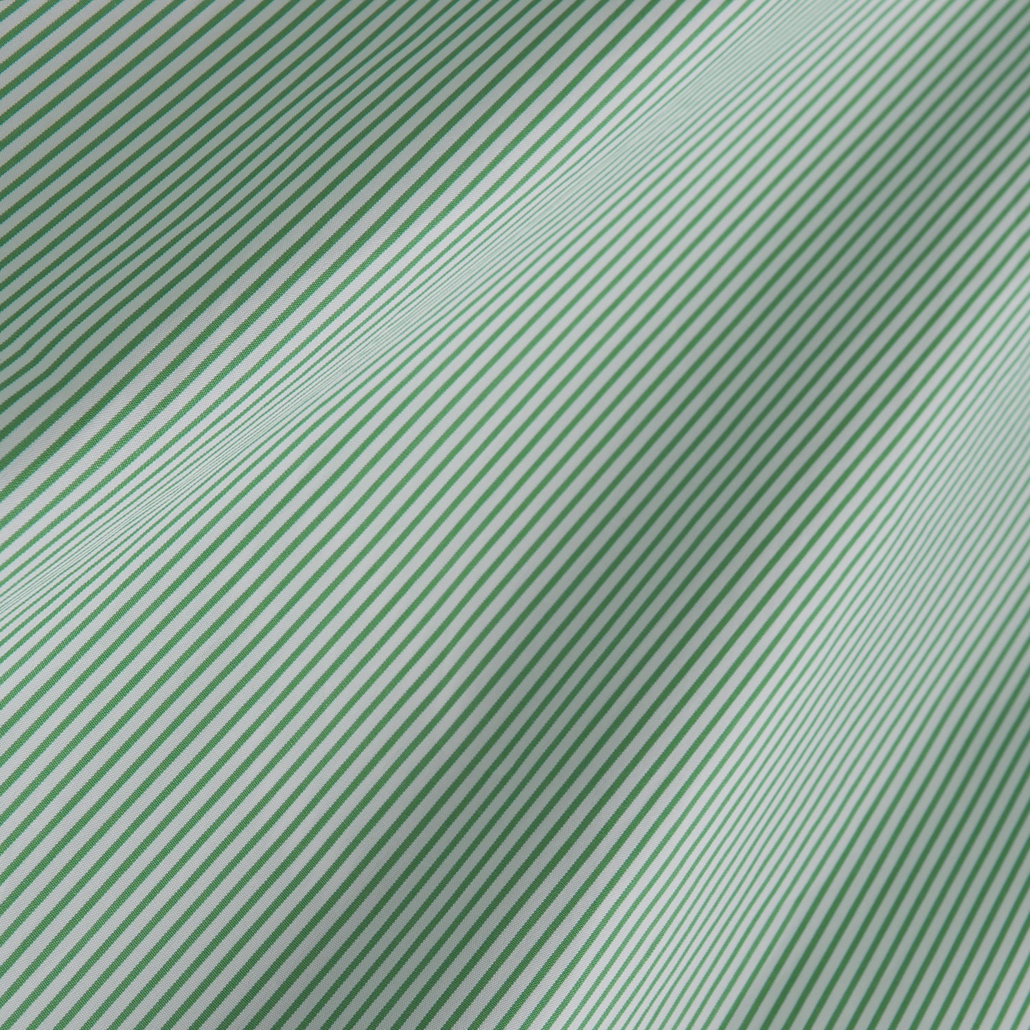View 7 of product A man stands against a plain background, wearing a Turnbull & Asser Green Fine Stripe Regular Fit Shirt with a T&A collar, paired with a yellow tie, dark trousers, and black shoes. He looks slightly left with his hands at his sides.