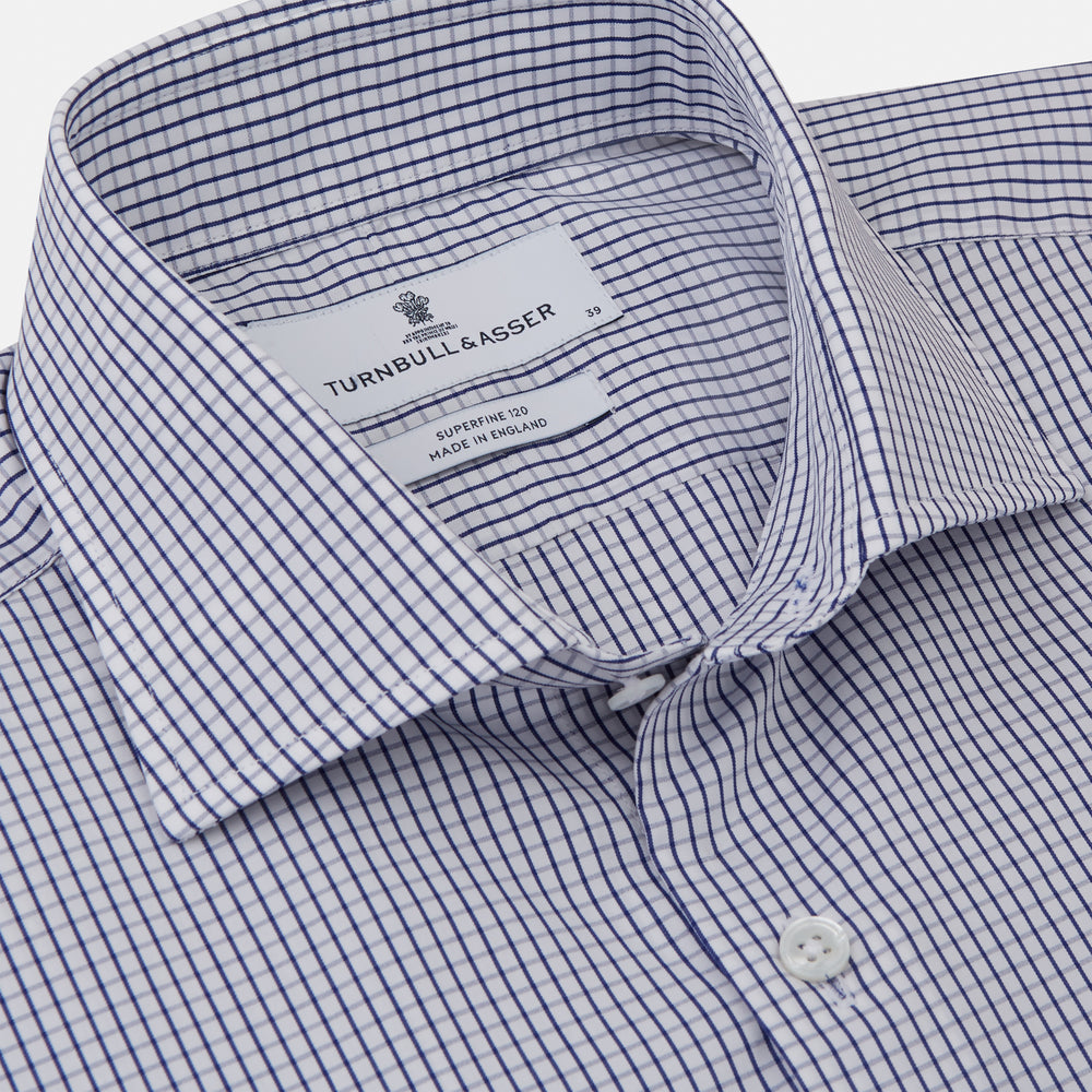 The Turnbull & Asser Blue Check Tailored Fit Shirt features a Kent collar, 2-button cuffs, and white buttons. Made from fine Italian cotton with a small blue and white checkered pattern, it's displayed on a plain white background.