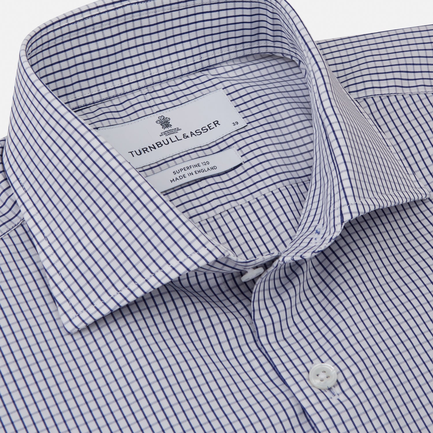 View 2 of product The Turnbull & Asser Blue Check Tailored Fit Shirt features a Kent collar, 2-button cuffs, and white buttons. Made from fine Italian cotton with a small blue and white checkered pattern, it's displayed on a plain white background.