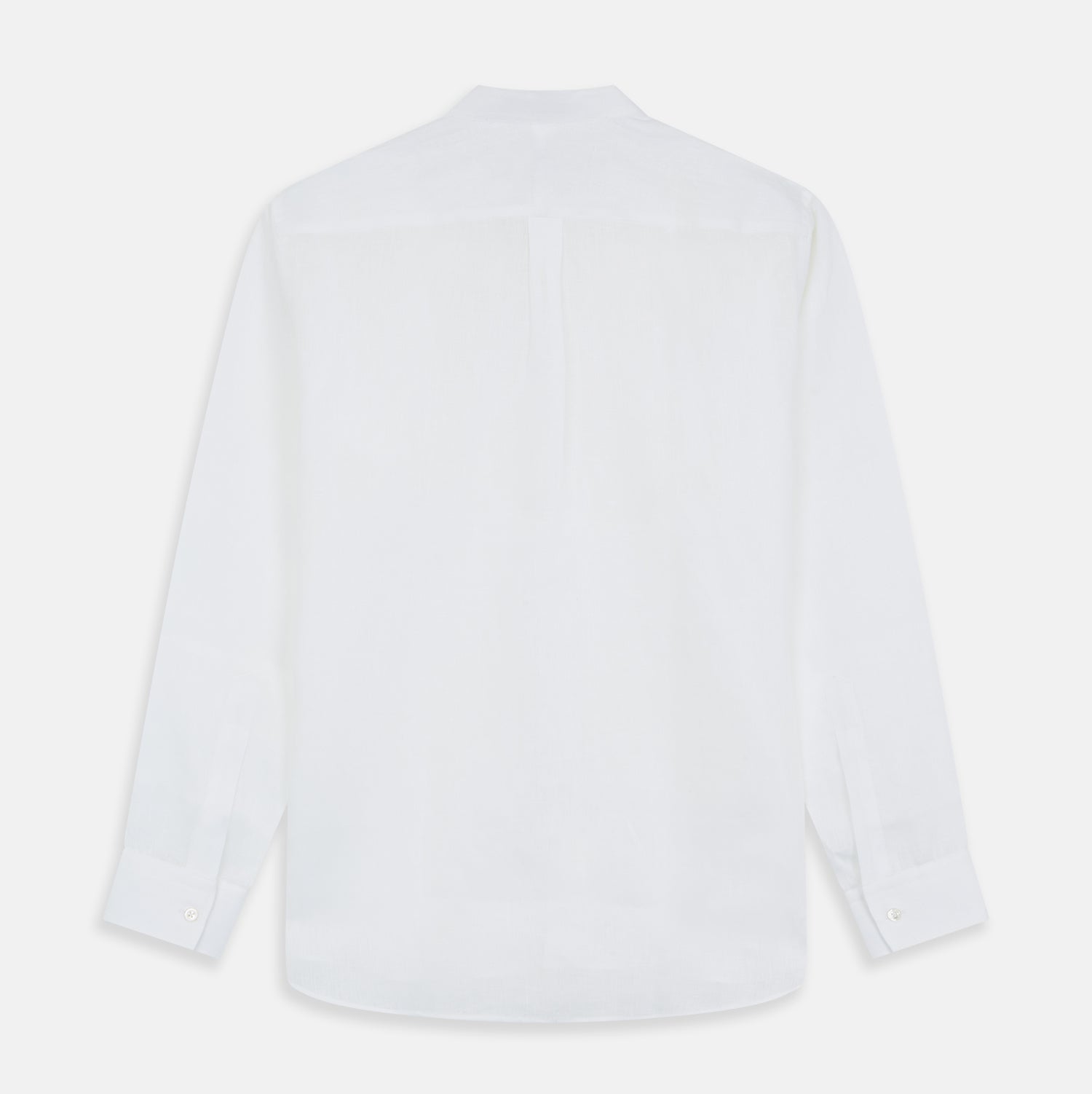 View 7 of product A man stands against a beige background, wearing the Turnbull & Asser White Linen Weekend Fit Blake Shirt, dark trousers, and beige sneakers. With one hand in his pocket and a neutral expression, he captures effortless weekend style.