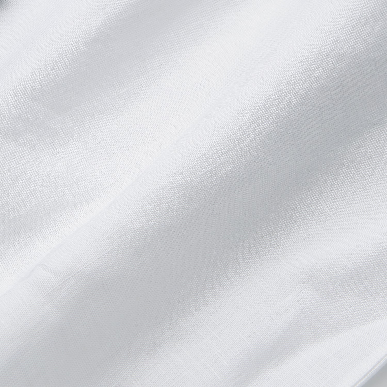 View 5 of product A man stands against a beige background, wearing the Turnbull & Asser White Linen Weekend Fit Blake Shirt, dark trousers, and beige sneakers. With one hand in his pocket and a neutral expression, he captures effortless weekend style.