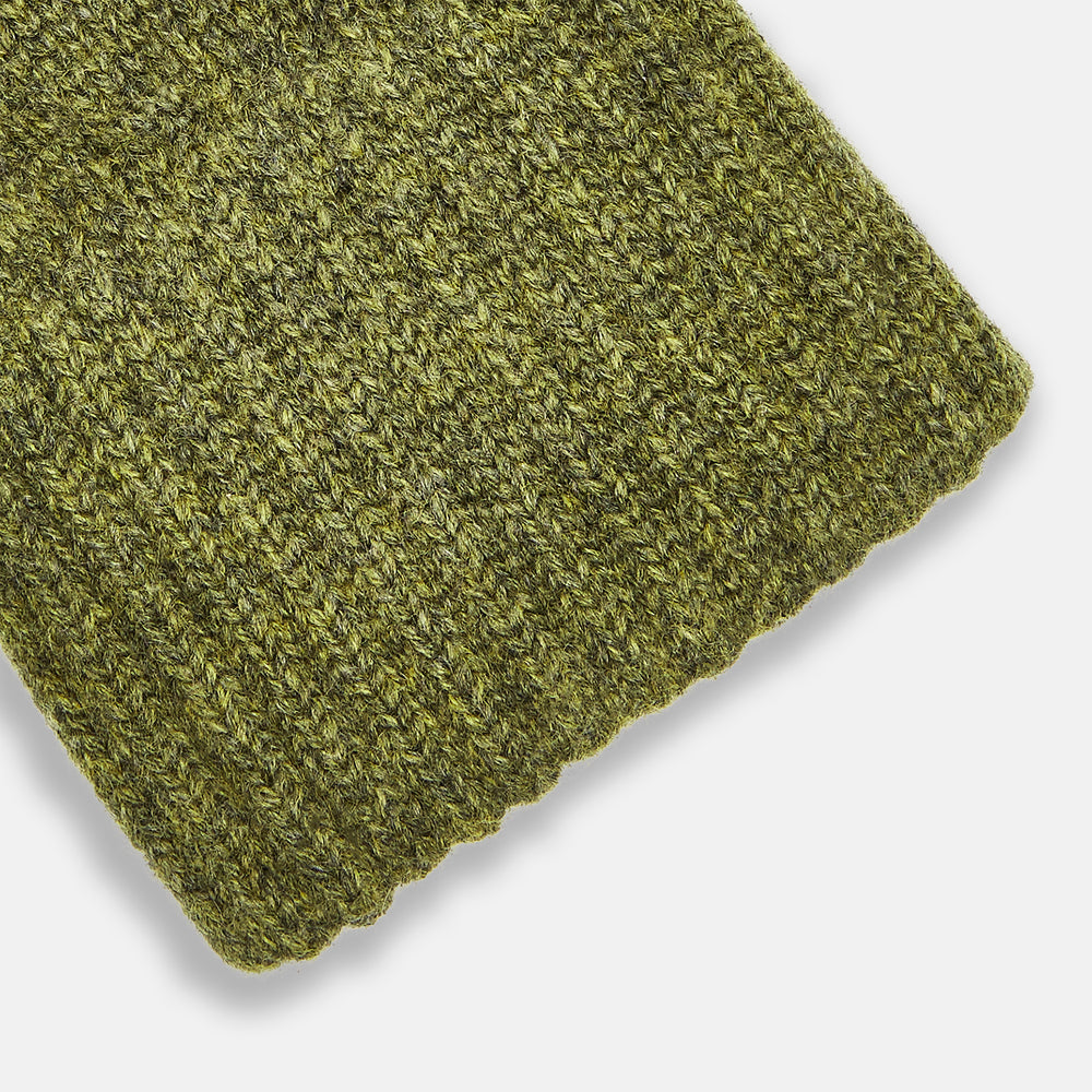 Turnbull & Asser's Green Multi Cashmere Gloves—an elegant Scottish knitwear piece—feature ribbed cuffs and an olive-toned design, showcased here laid flat on a white background.