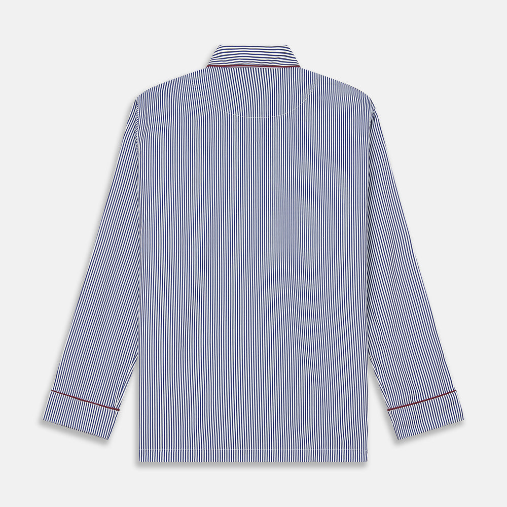 The Turnbull & Asser Navy & White Stripe Cotton Modern Pyjama Set features blue and white Bengal stripes with red piping, a long-sleeve button-up top, chest pocket, and matching pants. Shown laid flat on a white background.
