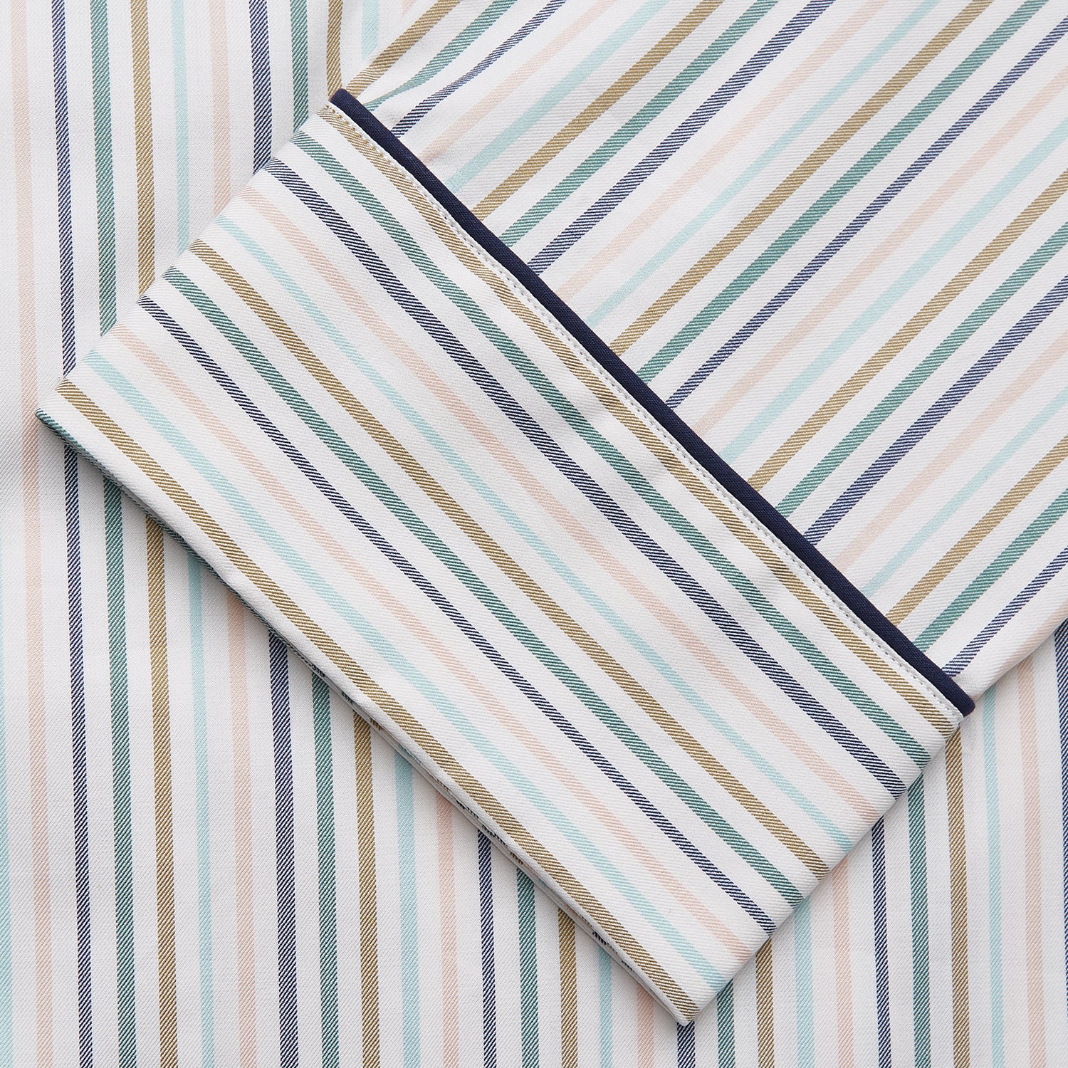 View 4 of product Turnbull & Asser’s Green Multi Stripe Harriet Women’s Pyjama Set features premium cotton, a button-up long-sleeve top, drawstring pants, and thin blue, green, and beige stripes on white with black piping for a timeless look.