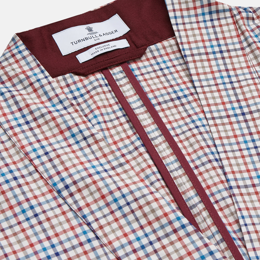 The Turnbull & Asser Burgundy Multi Check Cotton Kimono Gown is a knee-length robe with a burgundy check, red/blue/white pattern, long sleeves, a belt, and a solid burgundy inside collar.