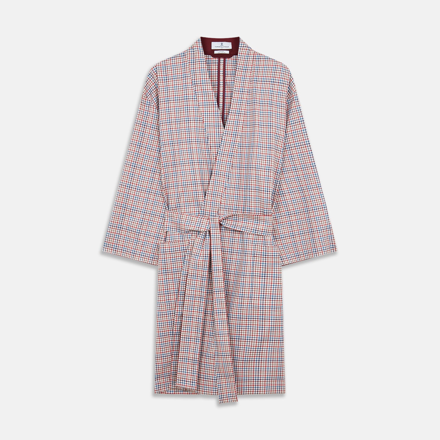 View 1 of product The Turnbull & Asser Burgundy Multi Check Cotton Kimono Gown is a knee-length robe with a burgundy check, red/blue/white pattern, long sleeves, a belt, and a solid burgundy inside collar.