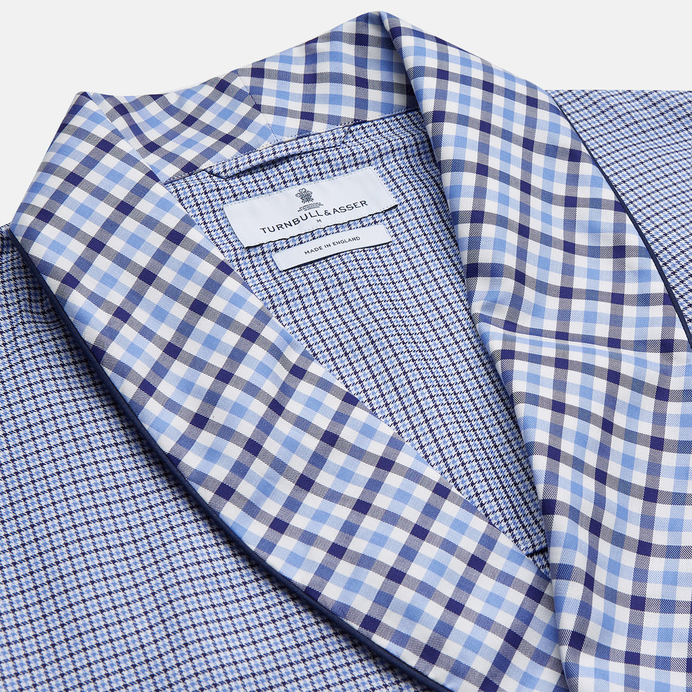 The Blue Multi Check Contrast Cotton Gown by Turnbull & Asser features long sleeves, a matching belt, front pocket, and contrasting checkered trim on the collar, cuffs, and pocket—offering a stylish, modern update to the classic gown.