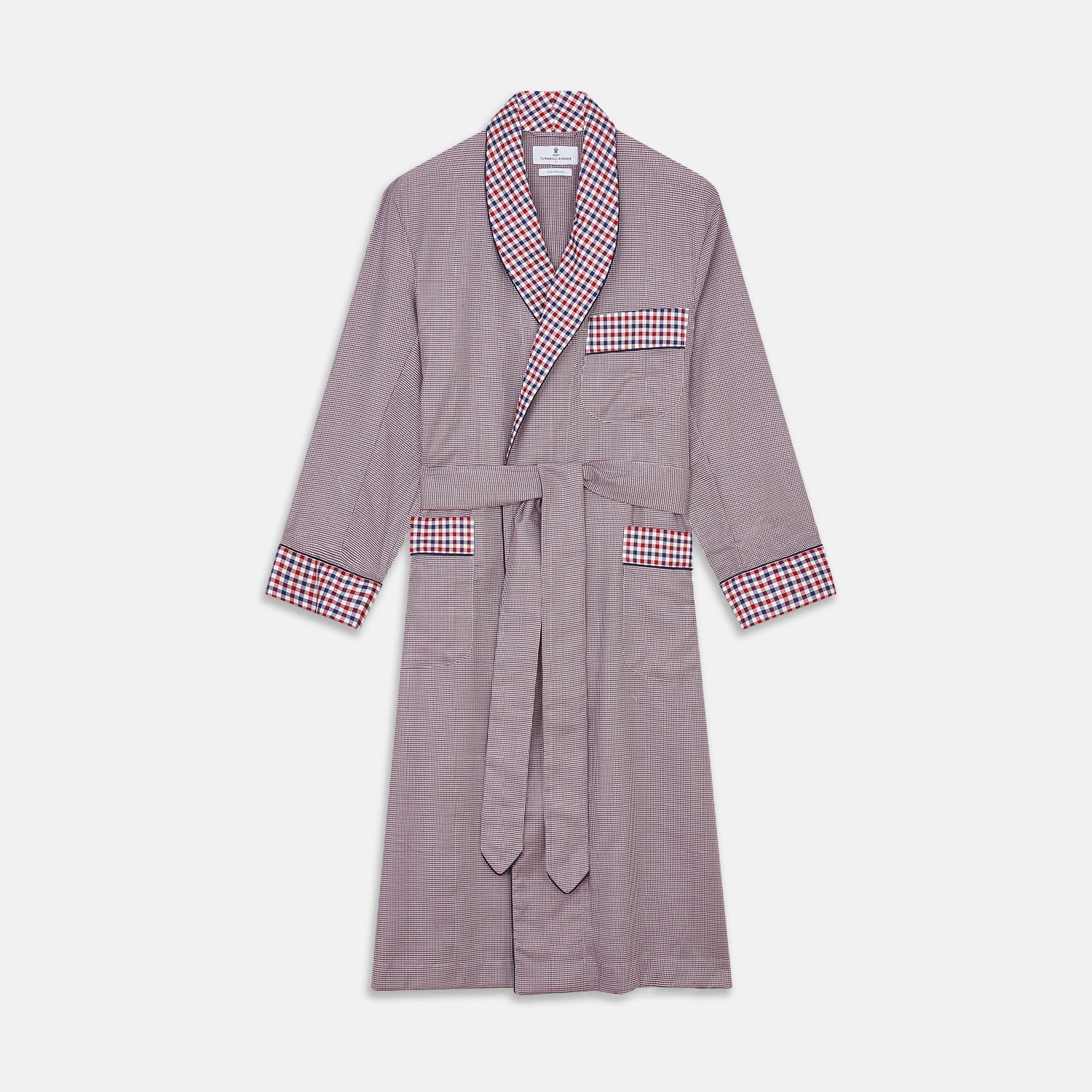 View 1 of product The Turnbull & Asser Burgundy Multi Check Contrast Cotton Gown features a long silhouette with a shawl collar, waist tie, and three pockets, accented by red, black, and white checkered trim—ideal for luxurious nights at home.