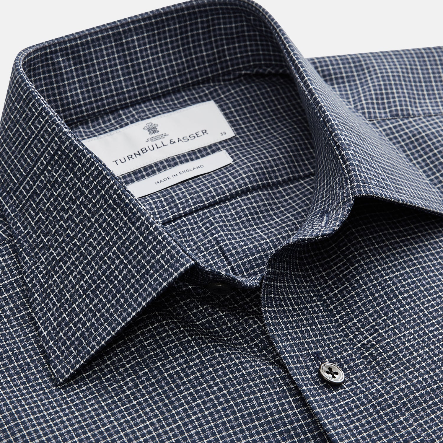 View 4 of product A man in a tie wears the Turnbull & Asser Navy Check Regular Fit Flannel Shirt with T&A collar and 3 button cuffs.