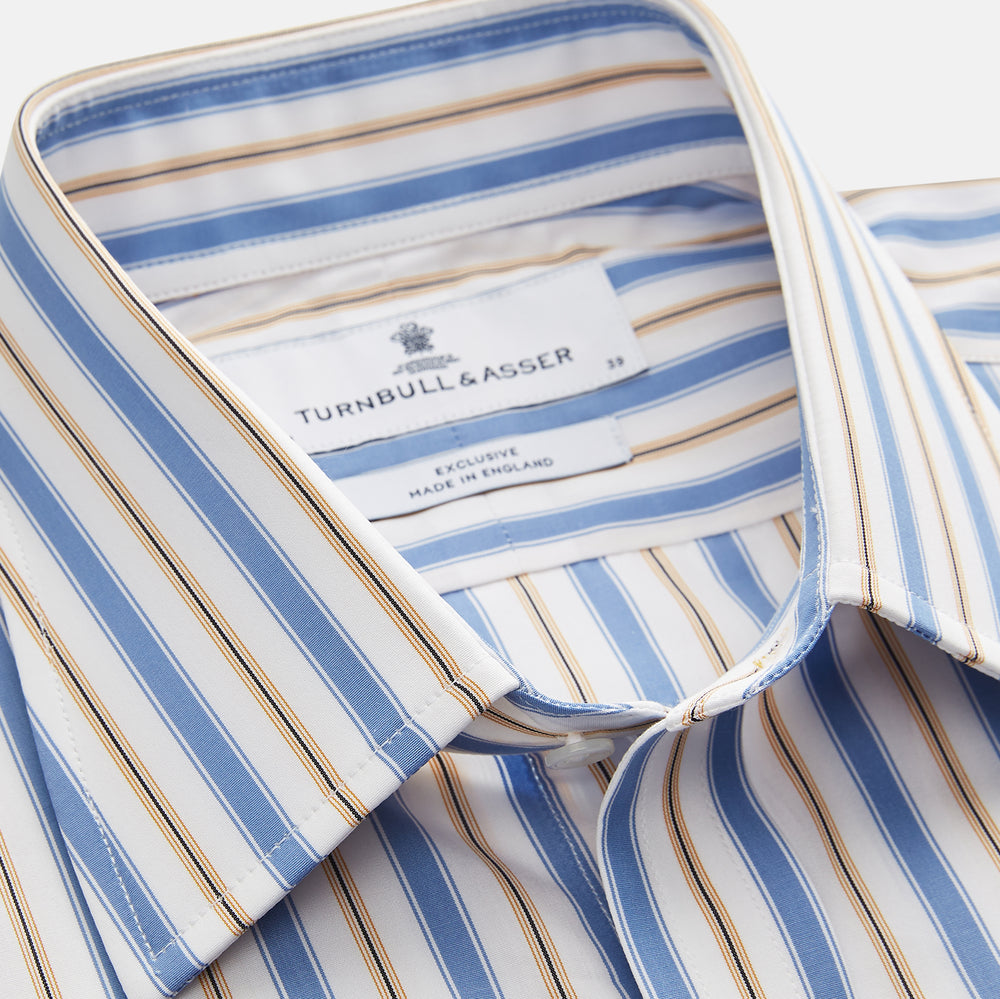 The Turnbull & Asser Blue Multi Stripe Regular Fit Shirt features a classic T&A collar, 3 button cuffs, and vertical blue, white, and yellow stripes for a timeless look.